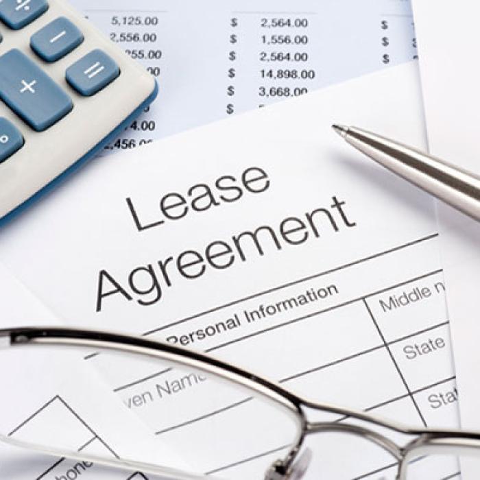 Lease agreement with pen, calculator and glasses